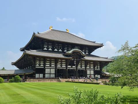       A historic temple with visitors walking around.
  