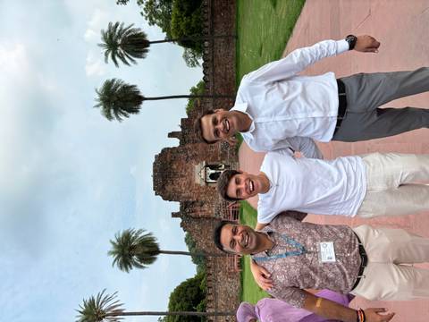       Group photo in front of ancient ruins with trees.
  