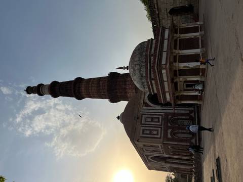 The Qutub Minar standing tall against the evening sky.