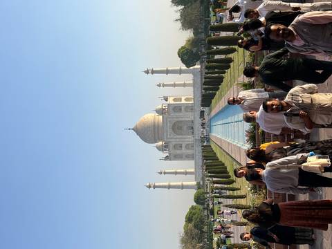 Tourists visiting the Taj Mahal with a clear blue sky.