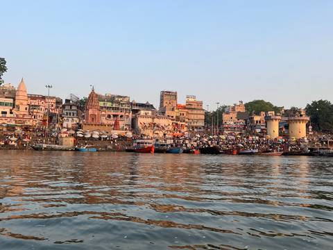 View of Varanasi ghats on the Ganges River during twilight.