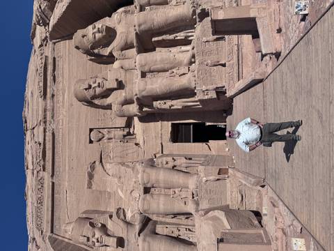 Man standing in front of the Great Temple of Ramses II at Abu Simbel.