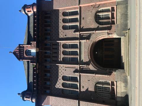 Front view of a historic red brick building with architectural details.