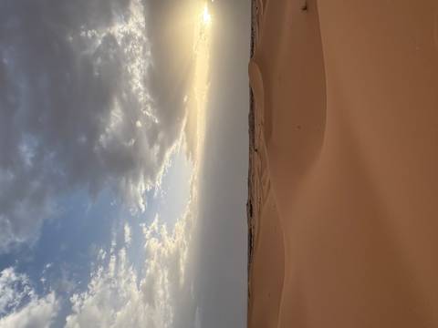 Sand dunes under a cloudy sky.