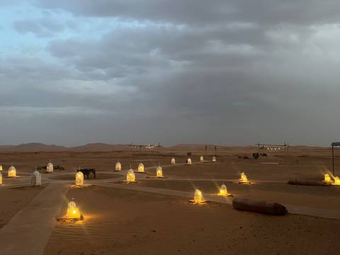       Desert camp with lanterns lighting up the evening.
  
