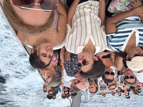 Crowded boat cruise with people seated on deck.