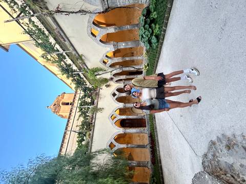 Three people posing in an ancient courtyard.