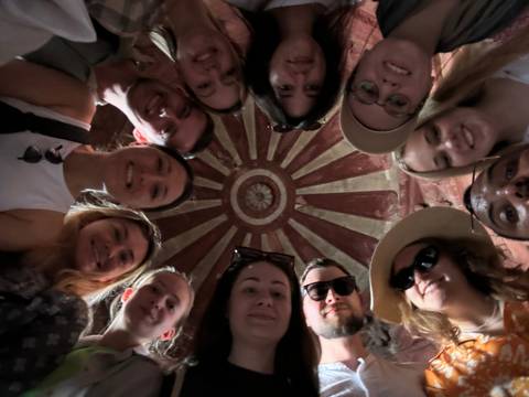 Group of people looking up at a colorful circular pattern.