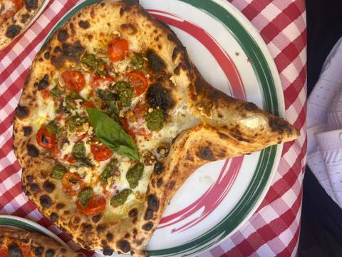 Naples-style pizza with fresh toppings and basil.
