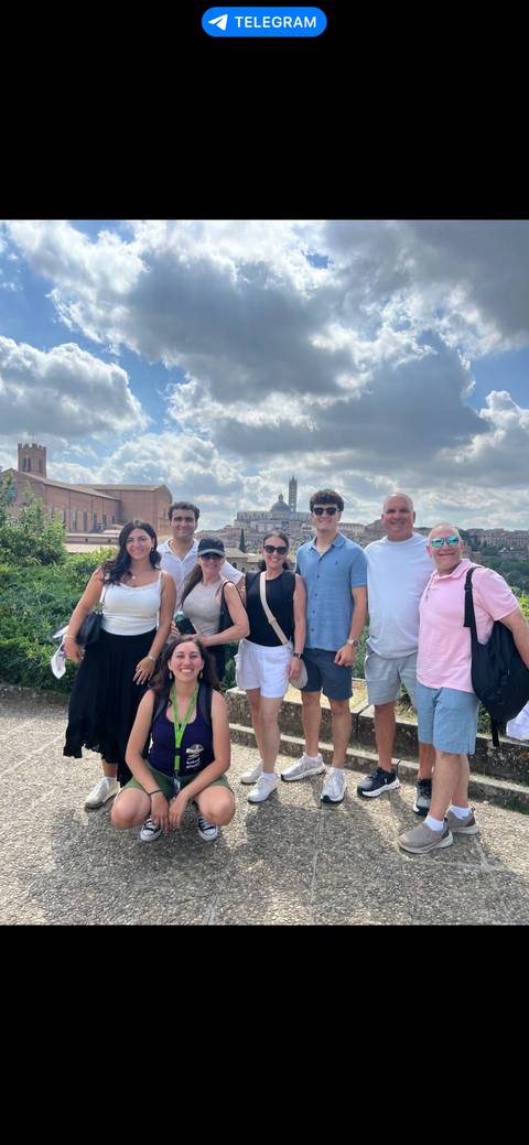 Group of people posing with a cityscape in the background.