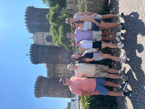       Group of people posing in front of a historical castle
  