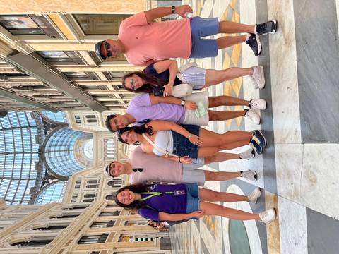 Group of people posing inside a large building with glass roof