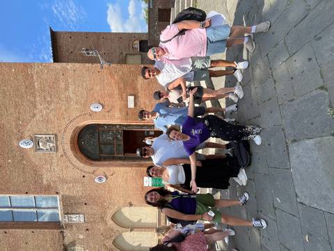 Group of people posing in front of a historical building entrance