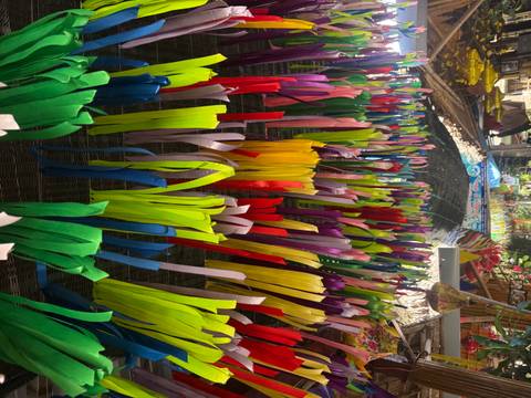 Colorful ribbons hanging in the air at a market.