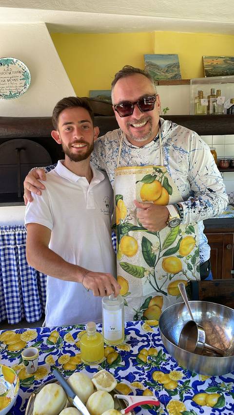       Two people in a kitchen, one wearing a lemon-themed apron
  