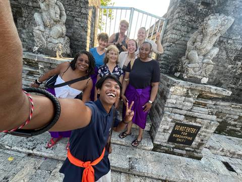 Group selfie in front of a historical gate with signs