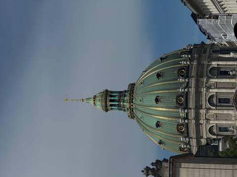 Green domed building against blue sky.