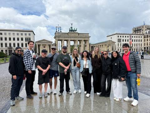 Group of people posing in front of Brandenburg Gate.