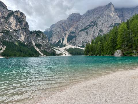       A pristine mountain lake with emerald waters, surrounded by dense forests.
  
