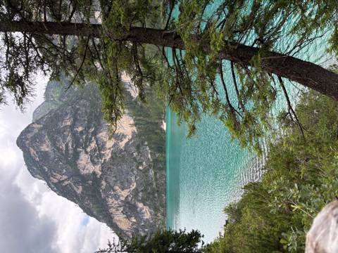       A picturesque blue lake with rocky cliffs and lush forest.
  