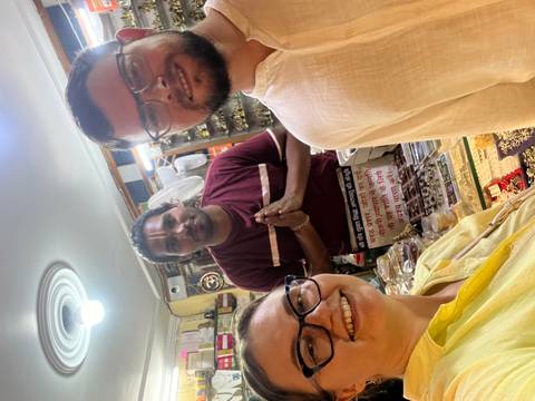Three people posing inside a shop with local goods.