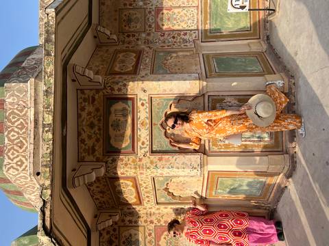       Woman posing against an ornate architectural background.
  