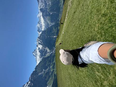 Person hiking with a view of snowy mountains.