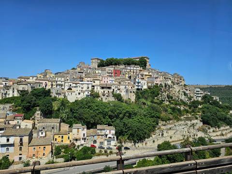Colorful hillside village with green vegetation.
