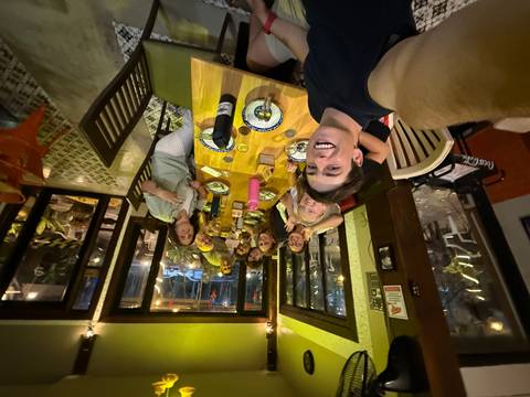 Group dinner indoor setting, people smiling.