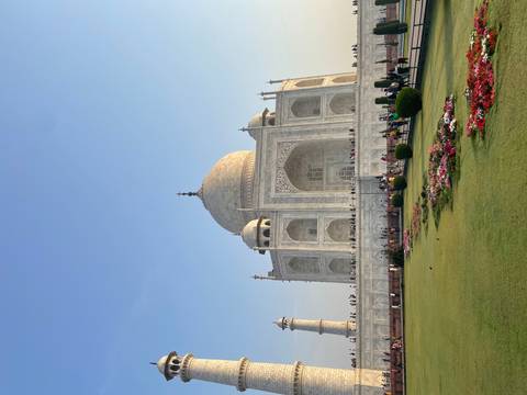 The Taj Mahal with well-maintained gardens and clear blue sky.