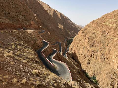Winding road through rocky cliffs in a desert landscape.