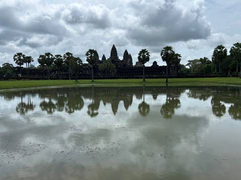 Reflection of Angkor Wat temple on the pond with cloudy sky.