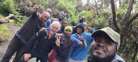       Group of hikers posing for a photo in a forested area.
  