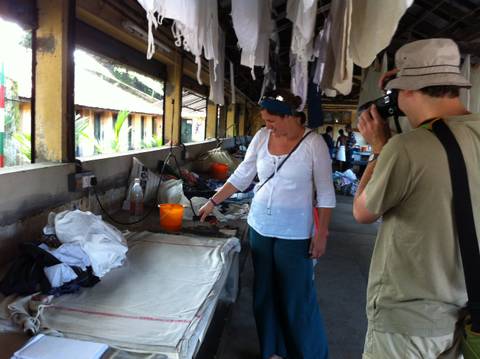 Tourists observing traditional laundry service in an outdoor facility.