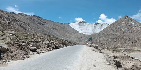 Road leading towards mountains with a glacier in the background.