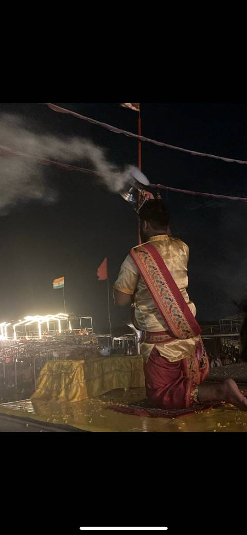       Person in traditional attire performing an evening ritual.
  