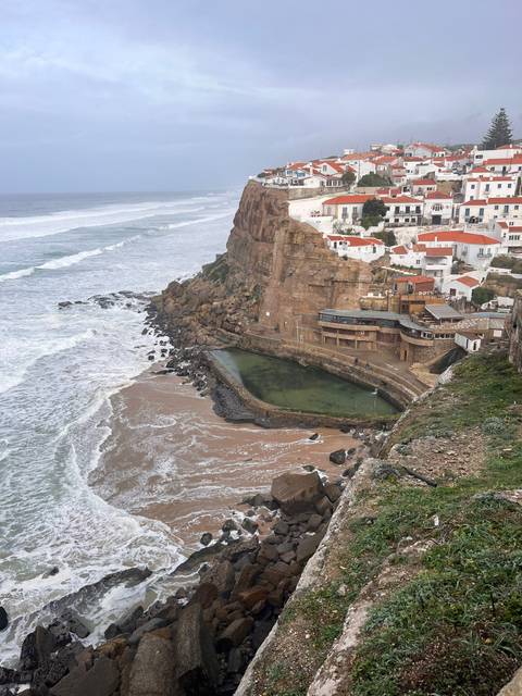 Coastal area with rocky cliffs and buildings.
