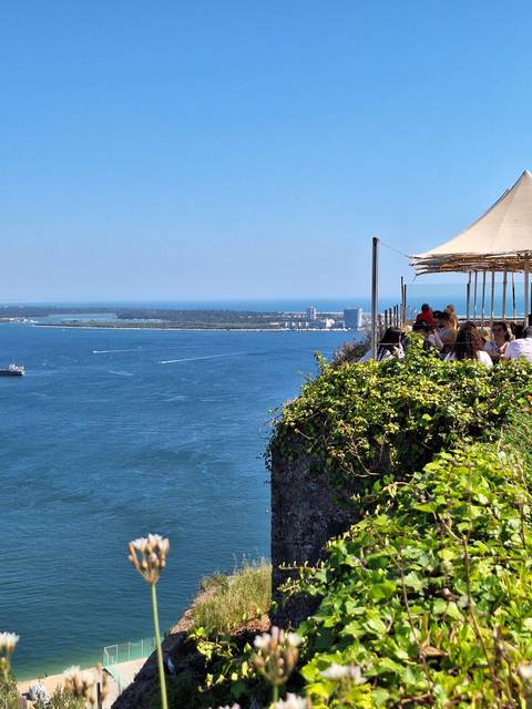 Outdoor dining area on a cliff overlooking the sea.