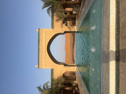       Pool with a view of the desert and arches framing the scene.
  