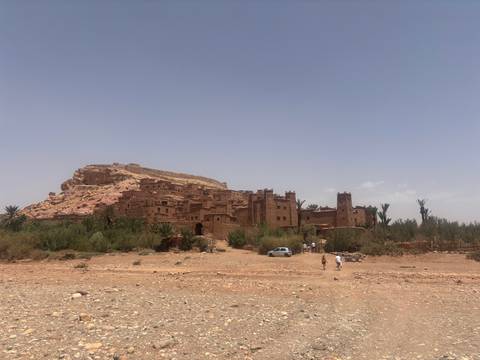       Ancient fortress on a rocky hill with scattered greenery.
  