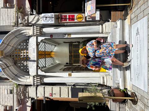       Two women posing in front of an entrance to a historic Turkish bath.
  