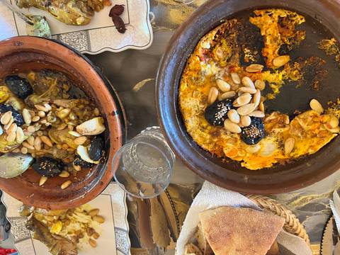       Traditional Moroccan dishes with almonds and preserved lemons served on a table.
  