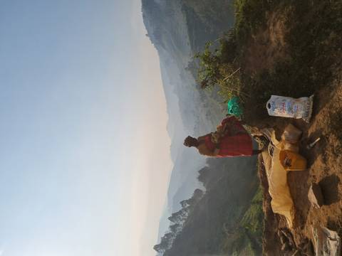 Person standing on a hill with scenic view.