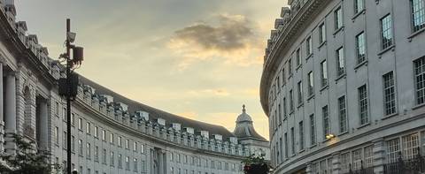 Curved buildings in London during sunset.