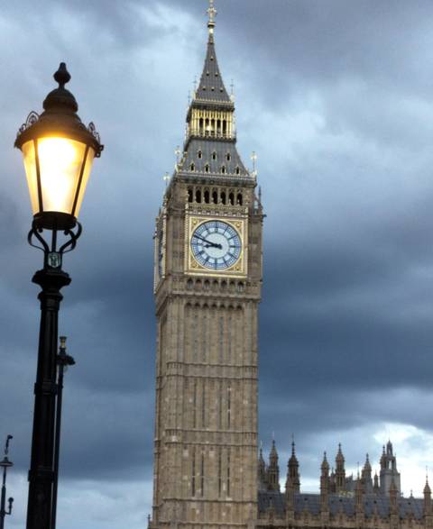 Big Ben clock tower illuminated against a dark sky.