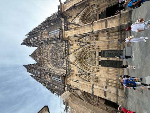       Gothic cathedral entrance with intricate carvings and people in front.
  