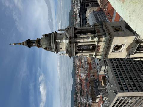       Church tower with a view of the city and mountains.
  