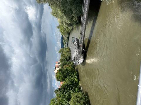       Modern bridge over a river under a cloudy sky.
  