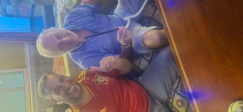       Two people smiling and showing thumbs up indoors.
  