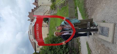       Two women posing beside a red sign frame
  